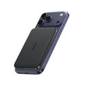Zwarte Anker powerbank magnetisch bevestigd aan de achterkant van een blauwe iPhone 15.