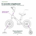 Technische tekening van een roze loopfiets met aanwijzingen voor montage. De tekst "In seconden omgebouwd" staat bovenaan.