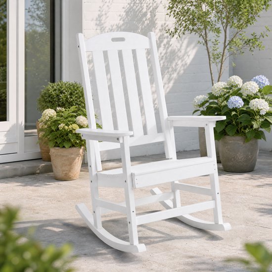 Witte Adirondack schommelstoel van kunststof op een terras, met potten met bloemen en planten ernaast.