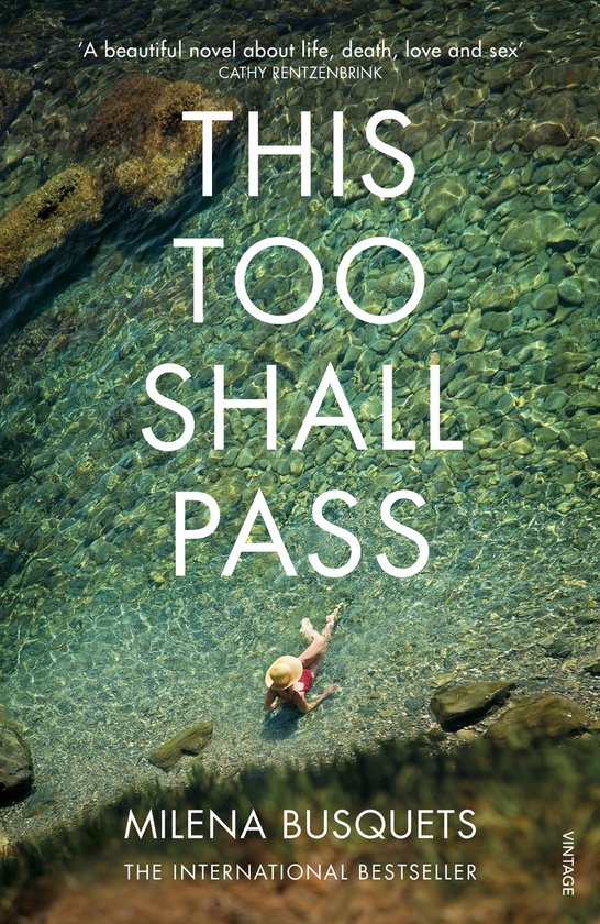 Boek "This Too Shall Pass" met een vrouw in bikini op een strand, liggend in het heldere water.