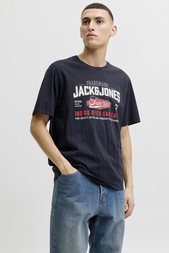 Man in Jack & Jones T-shirt met logo en spijkerbroek, handen in zakken.