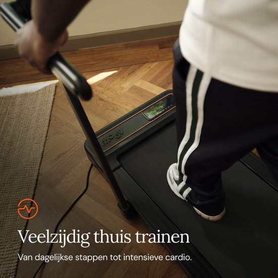 Een man met een witte shirt en sportbroek traint op een zwarte loopband.