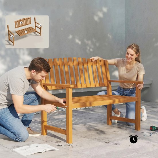 Man en vrouw monteren samen een houten tuinbank op een terras, met een instructie-afbeelding in de hoek.