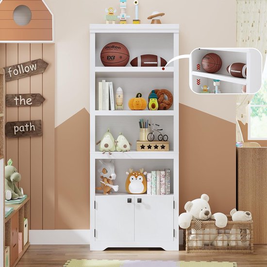 Witte boekenkast in kinderkamer, gevuld met speelgoed, ballen en boeken. Hangende borden met tekst 'follow the path' aan de muur.