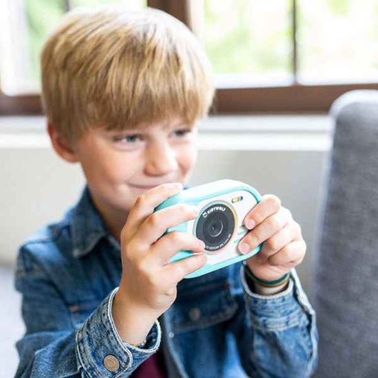 Jongetje met blond haar in een spijkerjasje houdt een cyaan Kidycam vast.