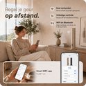 Vrouw bedient gouden FUSIFY LX geurverspreider met smartphone. Snelle verbinding, volledige controle en bediening via Wi-Fi en Bluetooth app.