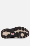 Zool van een bruine sneaker met zwart en beige profiel.