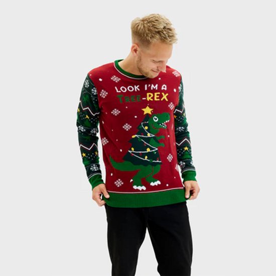 Een man kijkt naar beneden naar de dinosaurus op zijn rode kersttrui, die verkleed is als kerstboom met lichtjes en de tekst "LOOK I'M A TREE-REX".
