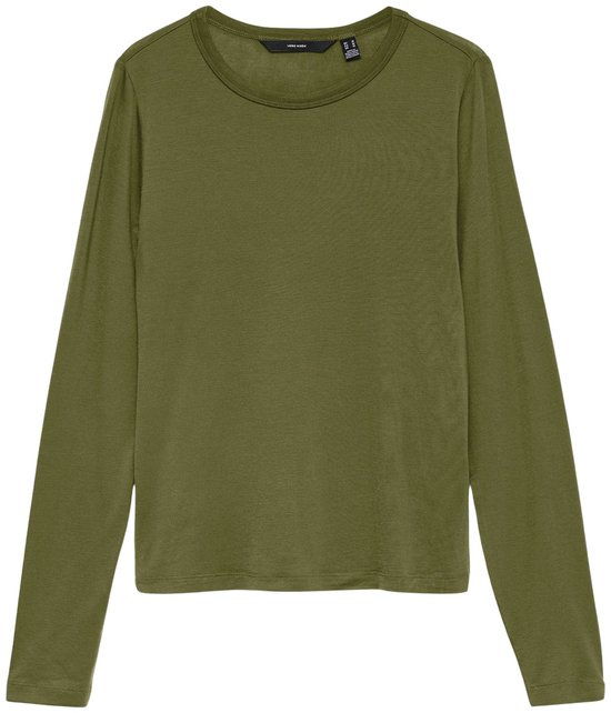 Model in een groen shirt met lange mouwen en een bruine broek, houdt een jas vast.
