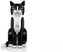Zwart-witte LEGO kat zittend, met staart, oren en witte poten.