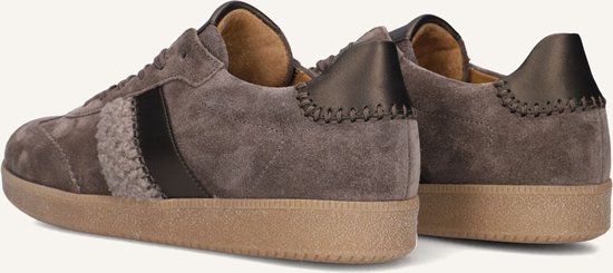 Achterkant van grijze suède sneakers met geborduurde hieldetails, bruine zool en beige opgestikte streep.