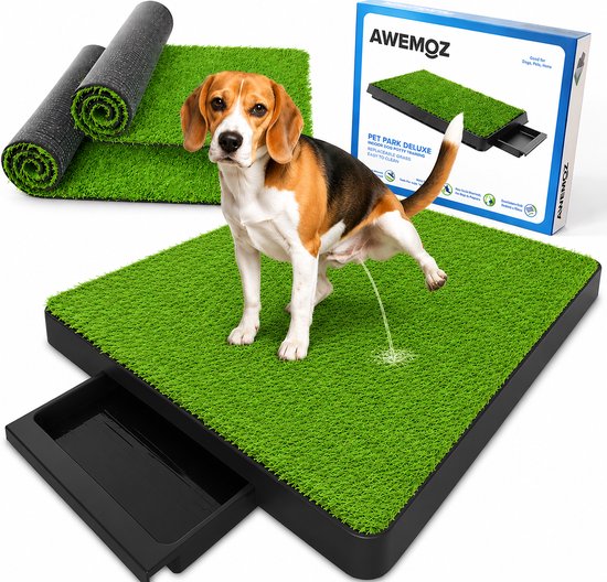 Beagle-hond plast op een groen hondenplas-toilet met opvangbak. Inclusief reservemat en doos met "AWEMOZ PET PARK DELUXE".