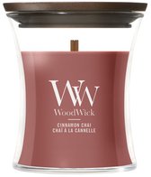 WoodWick geurkaars in glas met houten deksel. De kaars is roze en heeft "Cinnamon Chai" op de voorkant.