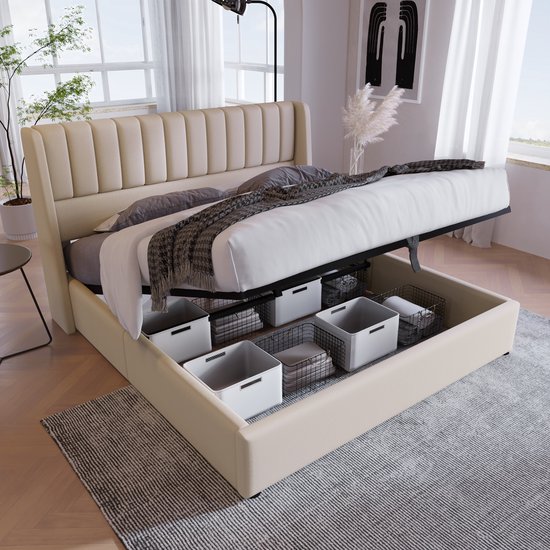 Lit rembourré beige clair avec sommier relevable et espace de rangement avec paniers. Deux tables de chevet blanches.