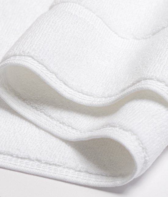Detail van de zijkant van een witte badmat met gestikte rand.