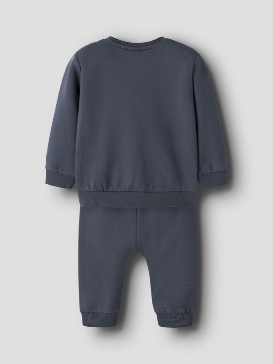 Donkerblauwe joggingbroek en bijpassende trui, achterkant zichtbaar.