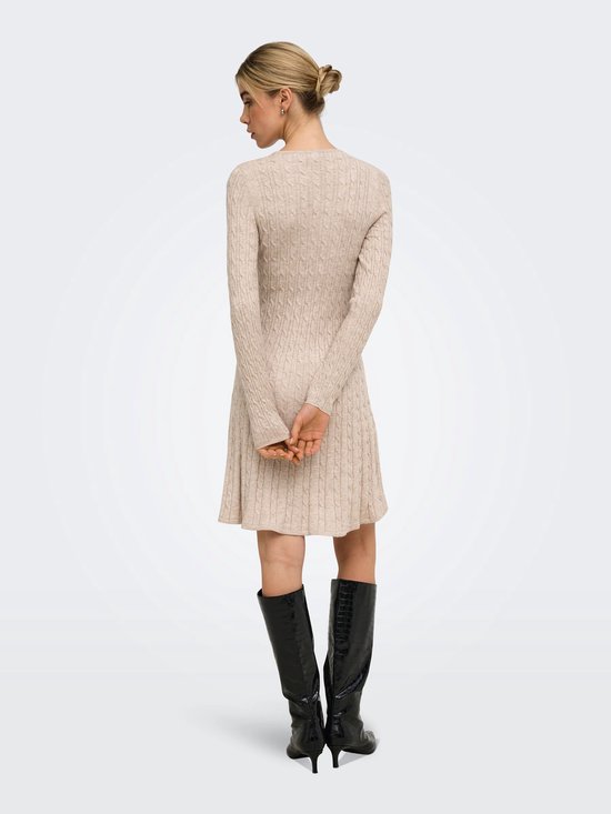 Model met beige gebreide jurk met kabelpatroon, van achteren gezien.