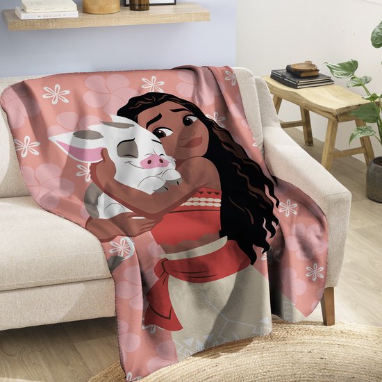 Vaiana knuffelt Pua op een roze plaid met bloemenprint, op een bank.