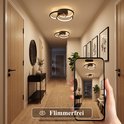 Hall met vier zwarte plafondlampen met ringen, gefotografeerd op een telefoon.