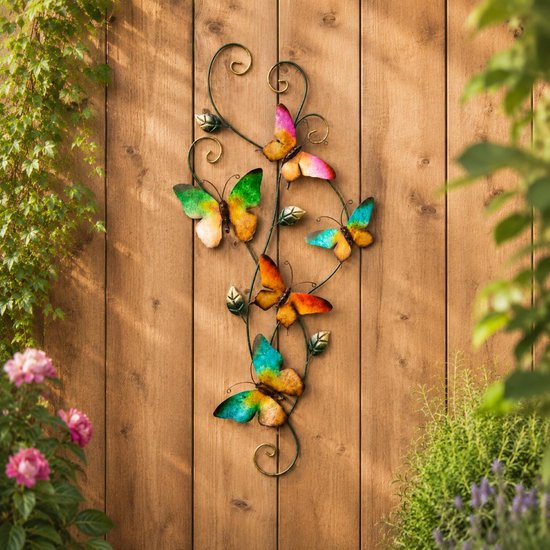Décoration murale avec cinq papillons métalliques colorés en vert, orange, jaune et rose, fixés à un cadre métallique ornemental vert foncé avec des feuilles.