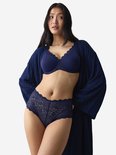 Model draagt een marineblauwe beha en slip met kant, met een bijpassende navy ochtendjas.