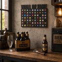 Donkergrijze bierdoppenbord met de tekst 'WALL OF FAME' bovenkant. Hieronder 5 rijen met bierdoppen. Zes flessen Hertog Jan bier in een doos op de voorgrond.