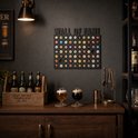 Zwart 'WALL OF FAME' bierdoppenbord met 5 rijen gevuld met diverse bierdoppen. Twee glazen bier, een houten kistje met zes flessen bier en een gouden houder met bestek op de voorgrond.