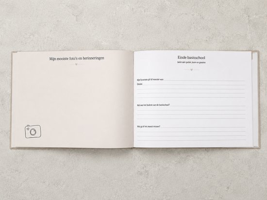 Een open boek met lege, lichtbeige pagina's. Links staat 'Mijn mooiste foto's en herinneringen' met een camera-icoon. Rechts zijn invulvelden.