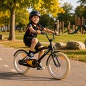 Jongen op een zwarte SJOEF kinderfiets met oranje vlammen op de kettingkast. Hij draagt een zwarte helm.
