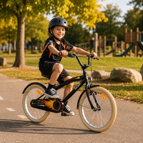 Jongen op een zwarte SJOEF kinderfiets met oranje vlammen op de kettingkast. Hij draagt een zwarte helm.