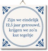 Een Delfts blauw tegeltje met de tekst 'Zijn we eindelijk 12,5 jaar getrouwd, krijgen we zo'n kut tegeltje'. Het tegeltje heeft een gouden haakje.