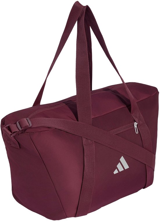 Bordeauxrode sporttas met hengsels, een schouderband en een zilverkleurig Adidas logo, schuin van voren gefotografeerd.