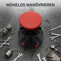 Rolkruk met rode zitting, omringd door gereedschap op een betonnen vloer. Tekst 'MÜHELOS MANÖVRIEREN'.