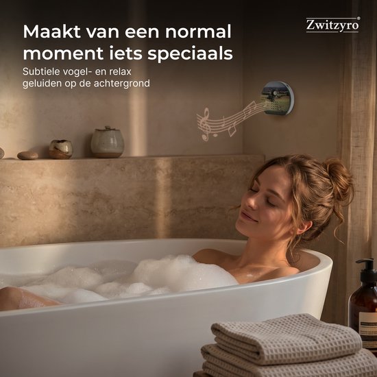 Vrouw ontspant in bad met de Zwitzyro in de muur, die subtiele vogel- en relaxgeluiden afspeelt.