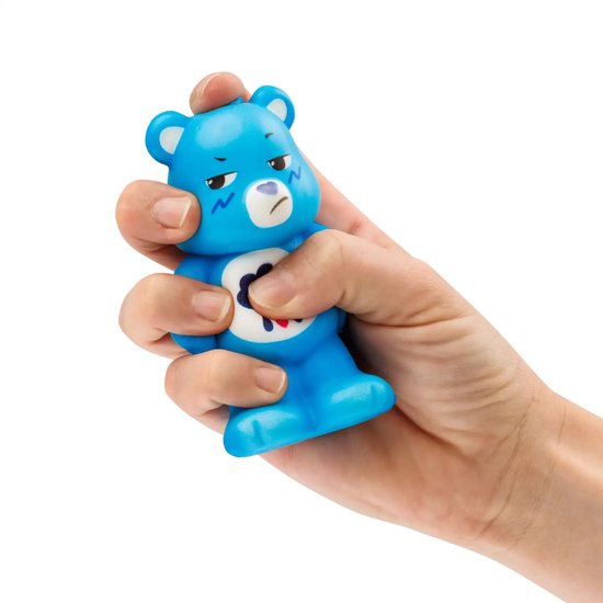 Blauwe Care Bear squishy met een norse uitdrukking, in een hand geknepen.