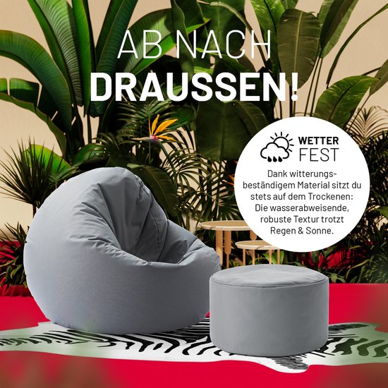 Grijze zitzak en poef in tropische setting met "Wetter Fest" aanduiding.