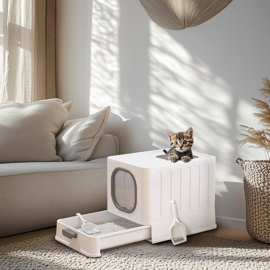Een witte kattenbak met grijze ingang en uittrekbare lade met kattenbakvulling, een kitten kijkt uit de bovenkant.