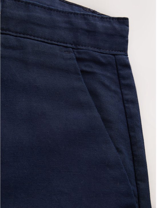 Detailopname van de zijzak op de donkerblauwe katoen-linnen chino.