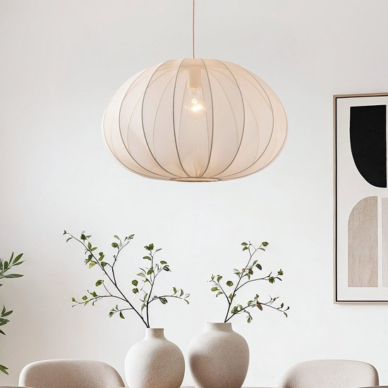 Suspension ronde en tissu beige clair au-dessus d'une table à manger.