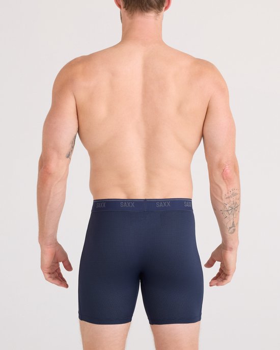 Vooraanzicht van een man die een donkerblauwe SAXX boxershort met ruitjespatroon en SAXX-band draagt.