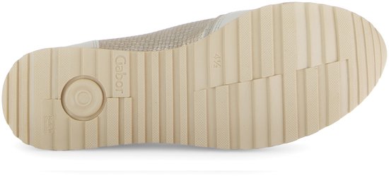 Onderkant van een beige sneaker met profielzool.