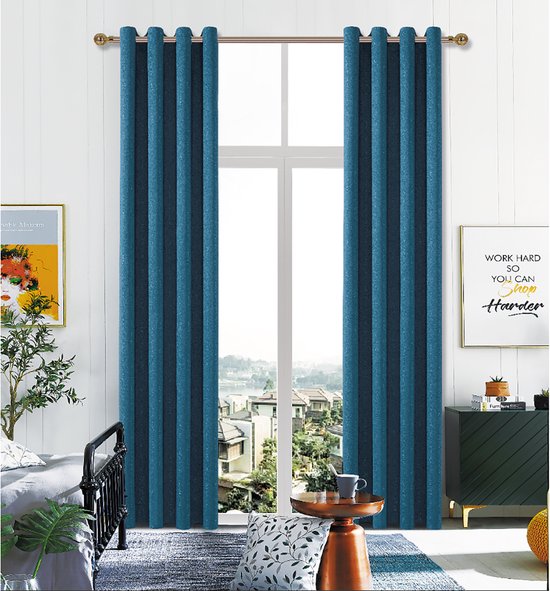 Twee donkerblauwe, verduisterende gordijnen met ringen hangen voor een raam in een woonkamer.