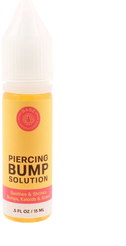 Piercing Bump Solution druppelflesje met een geel label met rode tekst 'Soothes & Shrinks Bumps, Keloids & Scars'.