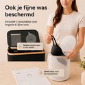 Een vrouw met een beigekleurig T-shirt houdt een zwarte bh vast die uit een wit gaasmandje komt. Naast de wasmand liggen een waszakje en een rond netje.