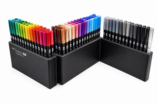Zwart display met 107 Tombow ABT Dual Brush pennen, geordend per kleur. Kleuren lopen uiteen van groen en blauw tot paars, rood, oranje, geel, bruin, grijs en zwart.