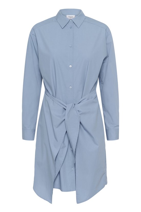 Robe chemise bleu uni à manches longues et ceinture nouée, debout sur fond blanc.