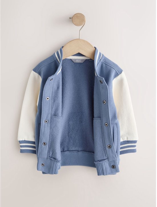 Open blauw-wit bomberjack hangend aan een hanger.