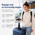 Vrolijke vrouw op vliegveld met rugzak en blauwe koffer, houdt zwarte bagageweegschaal vast. Iconen: wegen, compact, gebruiksvriendelijk.