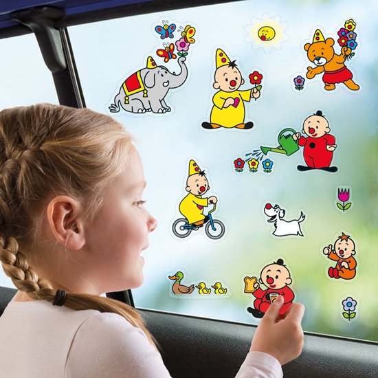 Meisje plakt raamstickers met Bumba, een olifant, beer, hond, baby's, eendjes en bloemen op het raam.