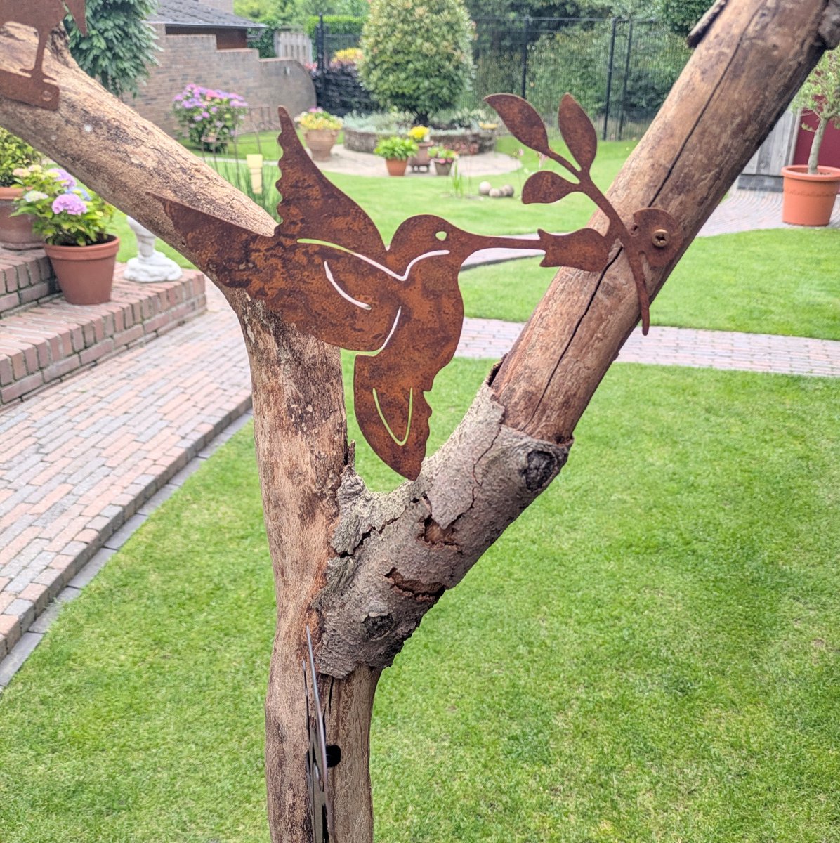 Ornament voor binnen of buiten in de tuin; Kolibrie van verroest metaal met takje